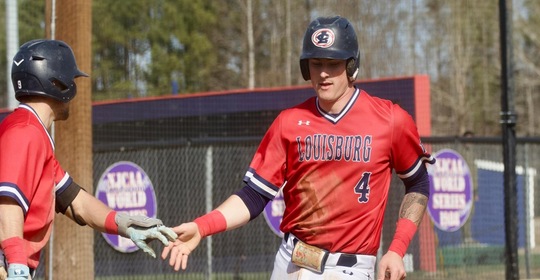 Payten Shipman slaps hand with teammate after scoring a run.
