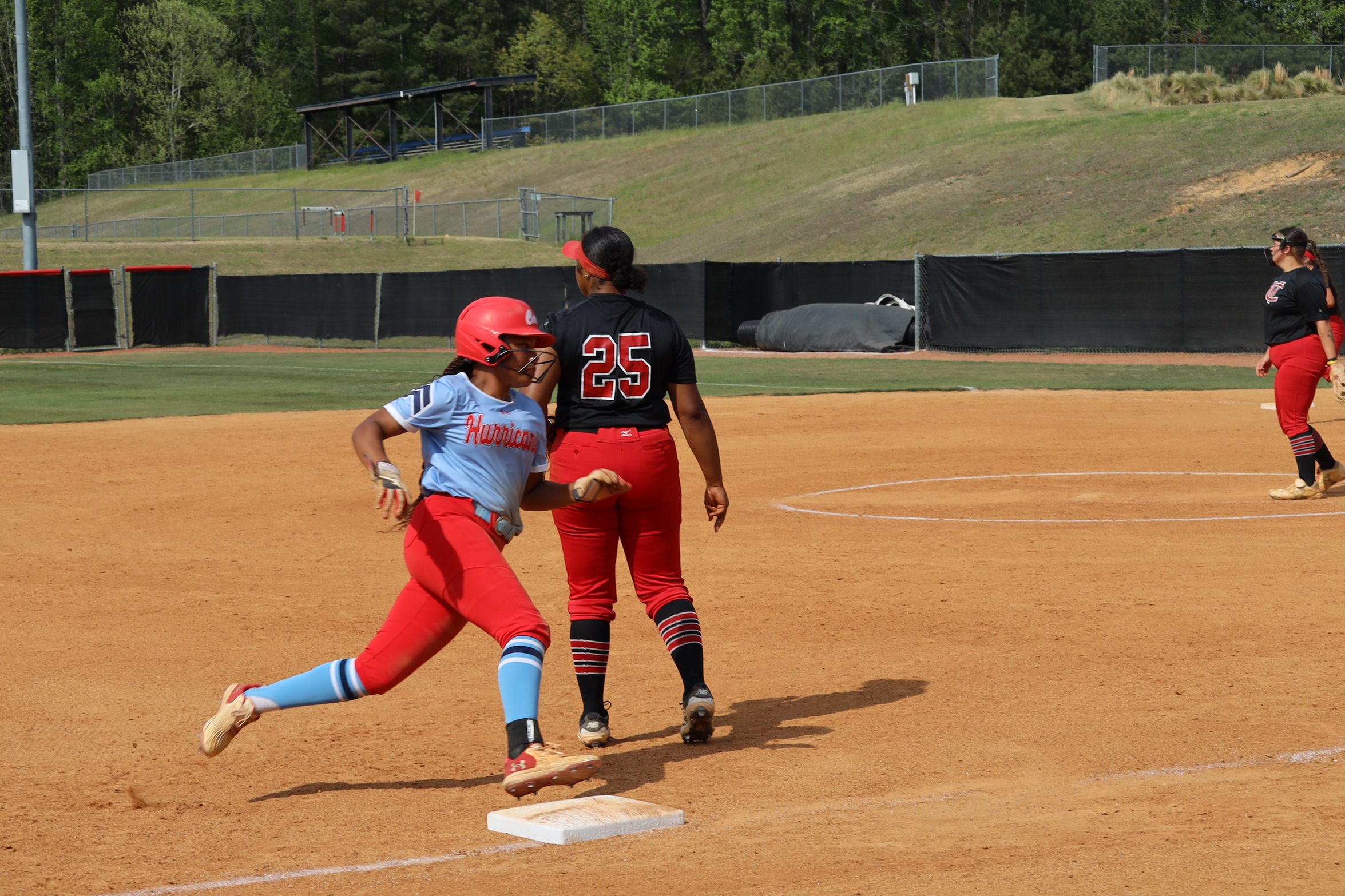 Louisburg Base runner rounding third base.